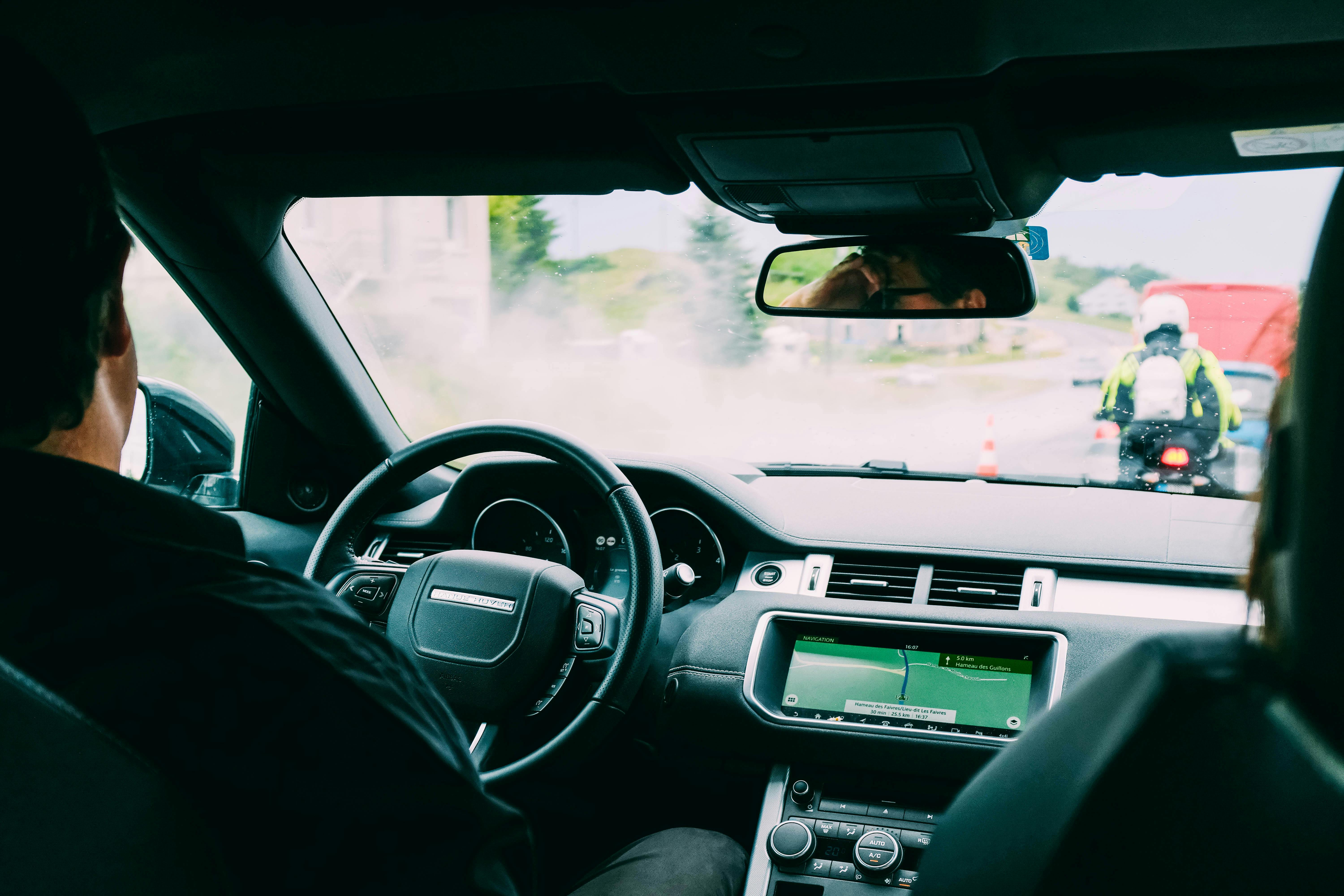 A dashboard view of a modern car showing safety diagnostic icons and a clear road ahead representing risk assessment